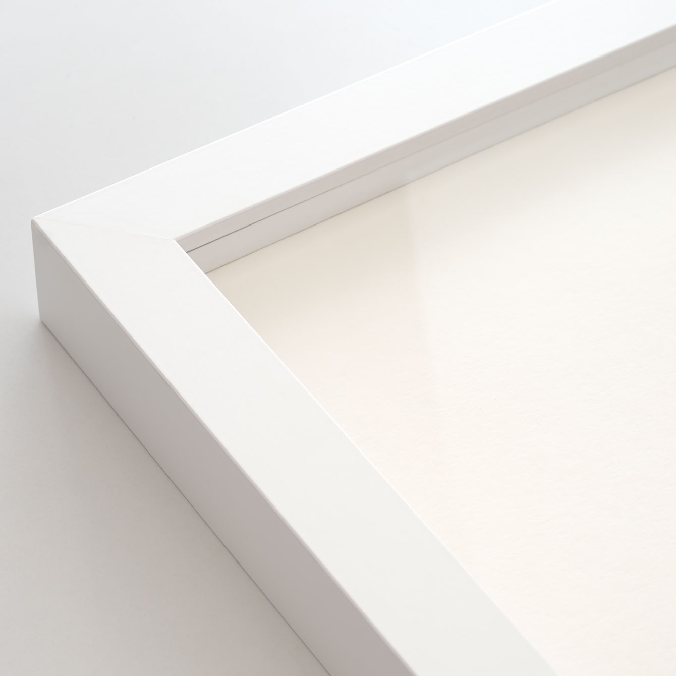 Ecke eines weißen Bilderrahmens mit artglass-Scheibe.