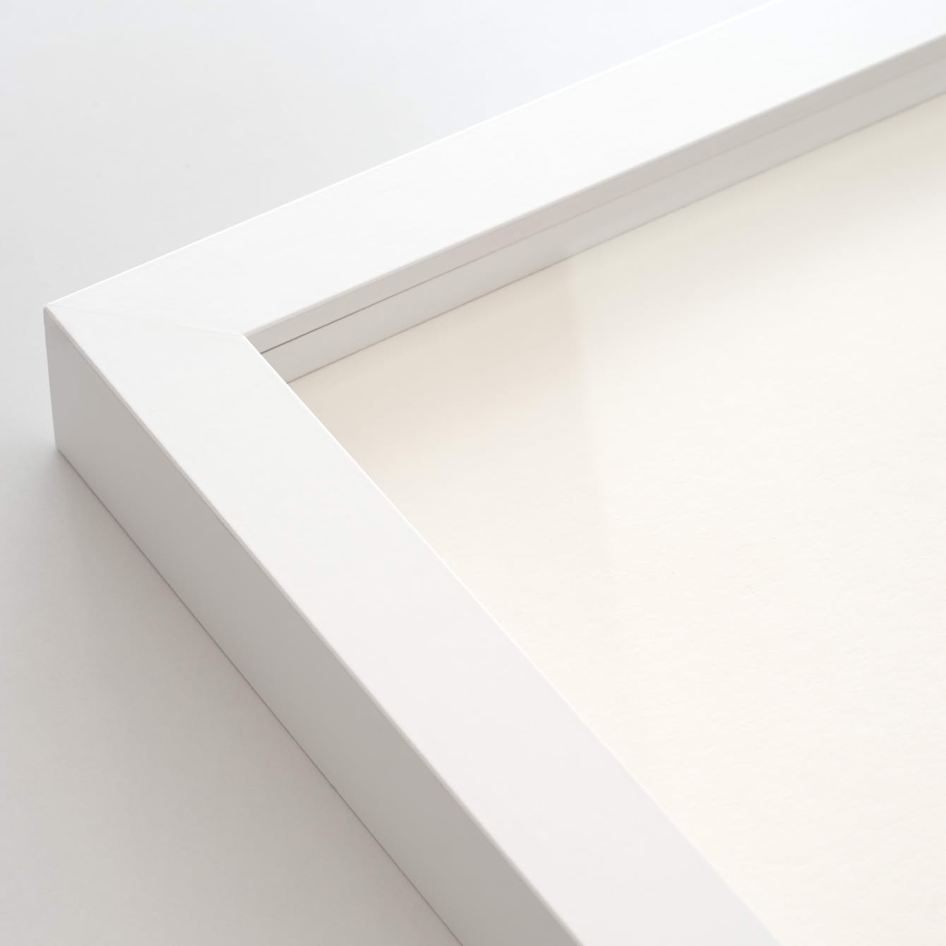 Ecke eines weißen Bilderrahmens mit artglass-Scheibe.